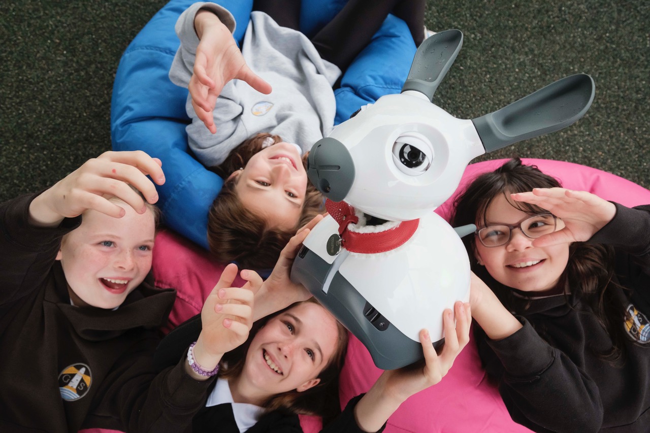 Pupils of St George’s School, Edinburgh playing with a robot dog