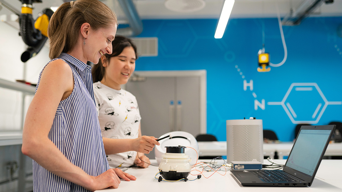Two people testing electronic equipment in a workshop
