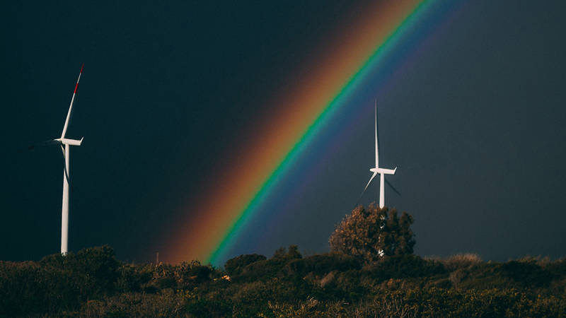 Wind turbines with a rainbow between them