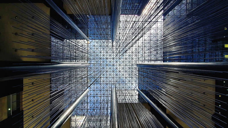 Looking up at the latticed roof of a building